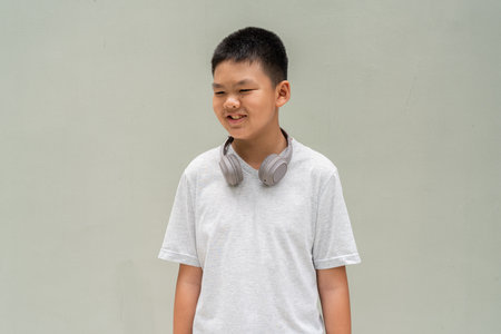 Thai Teenager Boy Portrait Against Plain Wall in Natural Lightの写真素材