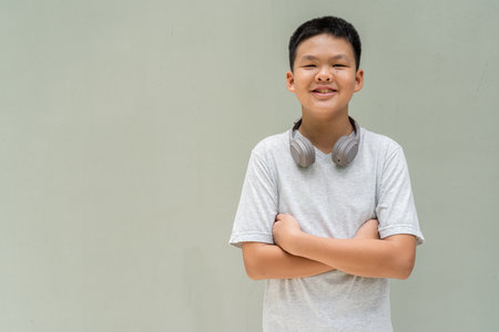 Thai Teenager Boy Portrait Against Plain Wall in Natural Lightの写真素材