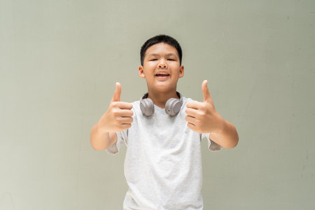 Thai Teenager Boy Portrait Against Plain Wall in Natural Lightの写真素材