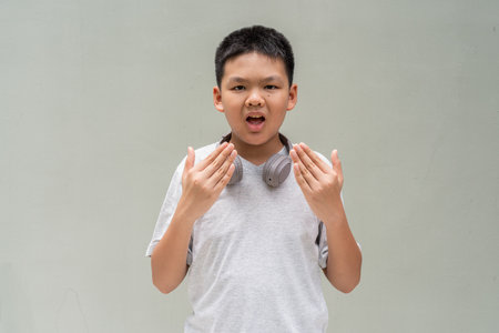 Thai Teenager Boy Portrait Against Plain Wall in Natural Lightの写真素材