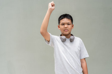 Thai Teenager Boy Portrait Against Plain Wall in Natural Lightの写真素材