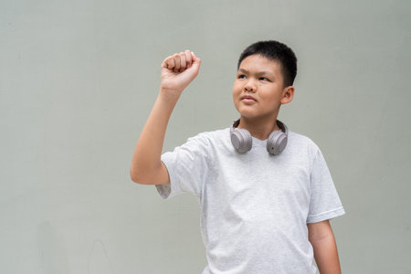 Thai Teenager Boy Portrait Against Plain Wall in Natural Light