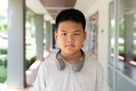 Portrait of Asian teenager boy outdoors with headphonesの写真素材