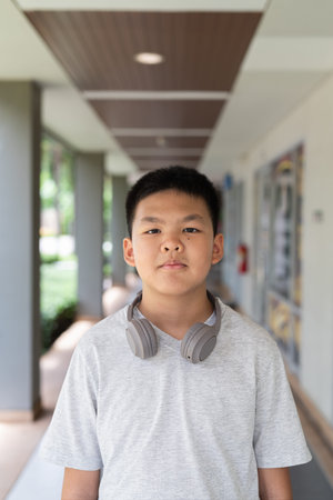 Portrait of Asian teenager boy outdoors with headphones