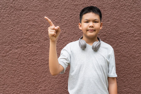 Thai Teenager Boy Portrait Against Plain Wall in Natural Light