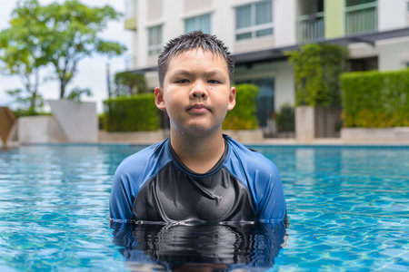 Teenage boy ready to swim in swimming pool during summerの写真素材