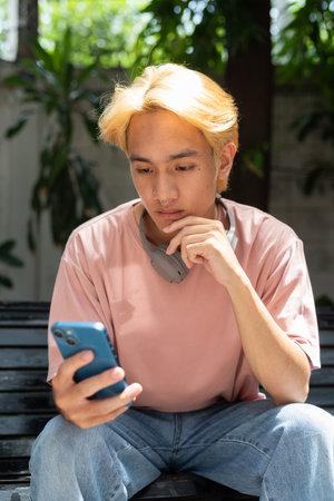 Portrait of young man using phone outdoors in cityの写真素材