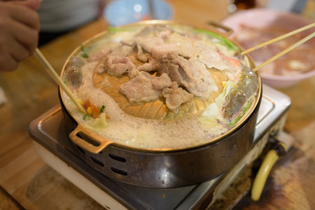Friends eating Thai Food BBQ Grill Mu Kratha at nightの写真素材