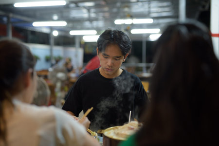 Friends eating Thai Food BBQ Grill Mu Kratha at night