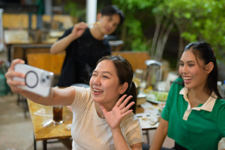 Friends eating Thai Food BBQ Grill Mu Kratha at nightの写真素材