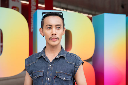 Portrait of confident non binary Asian gay man during pride outdoorsの写真素材
