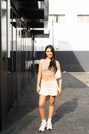 Confident Asian Woman Outdoors in Stylish Outfit During Dayの写真素材
