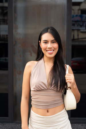 Confident Asian Woman Outdoors in Stylish Outfit During Dayの写真素材