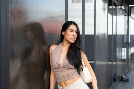 Confident Asian Woman Outdoors in Stylish Outfit During Dayの写真素材