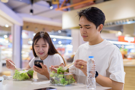 Young couple eating salad together in restaurant