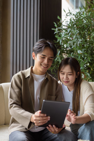 Couple using digital tablet computer in cafe while having coffeeの写真素材