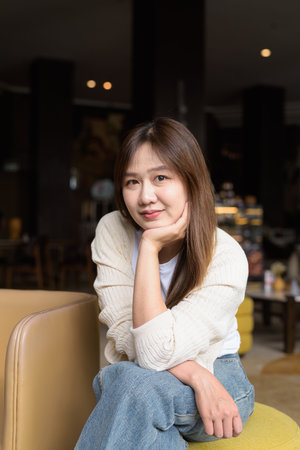 Young Asian businesswoman sitting in cafe restaurant smiling and looking at cameraの写真素材