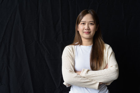 Studio portrait of young Asian woman against dark backgroundの写真素材