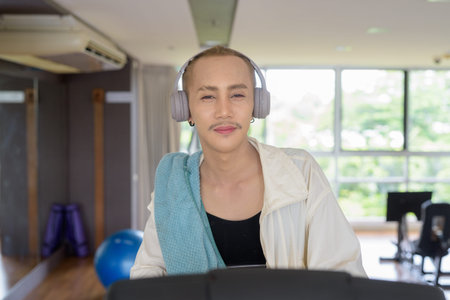 Non-binary Asian person exercising in gym wearing sportswear