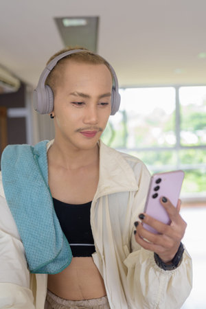 Non-binary Asian person exercising in gym wearing sportswear