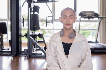 Non-binary Asian person exercising in gym wearing sportswearの写真素材