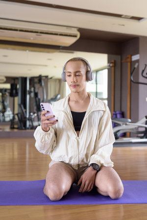 Non-binary Asian person exercising in gym wearing sportswearの写真素材