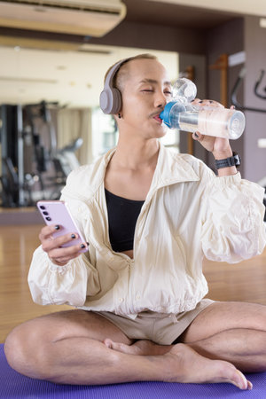 Non-binary Asian person exercising in gym wearing sportswearの写真素材