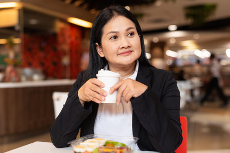 Portrait of woman in business clothes eating salad for lunch in restaurant