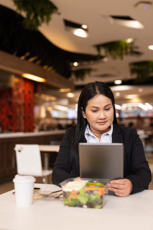Portrait of woman in business clothes eating salad for lunch in restaurant
