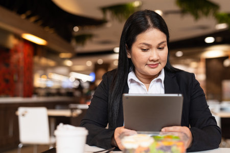 Portrait of woman in business clothes eating salad for lunch in restaurantの写真素材