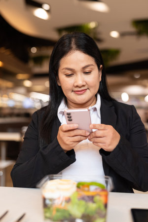 Portrait of woman in business clothes eating salad for lunch in restaurantの写真素材
