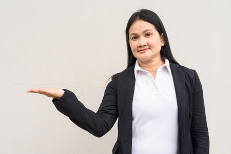 Portrait of mature Asian woman in business clothes against white backgroundの写真素材