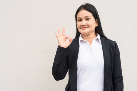 Portrait of mature Asian woman in business clothes against white backgroundの写真素材