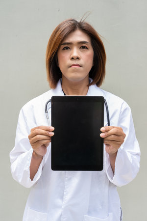 Portrait of Asian transgender non binary doctor with stethoscope. Diversity in healthcare.の写真素材