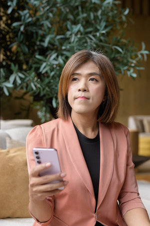 Confident Asian transgender non binary person in business attire at stylish indoor cafe restaurant