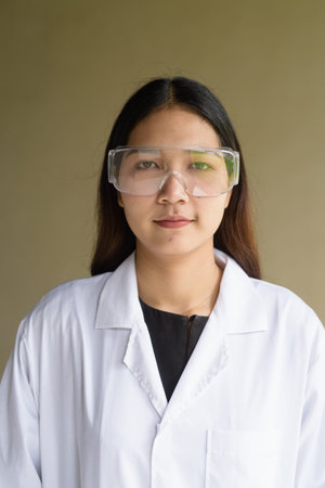 Young Asian scientist woman wearing lab coat and goggles