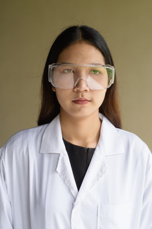 Young Asian scientist woman wearing lab coat and goggles