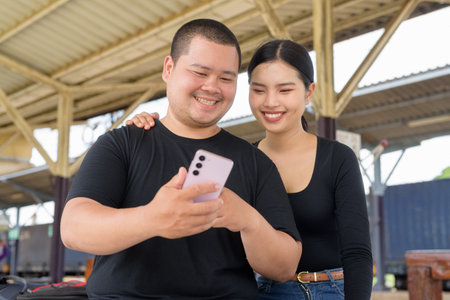 Young Asian couple in train station togetherの写真素材