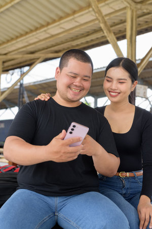 Young Asian couple in train station togetherの写真素材