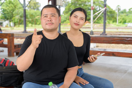 Young Asian couple in train station togetherの写真素材