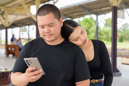 Young Asian couple in train station togetherの写真素材