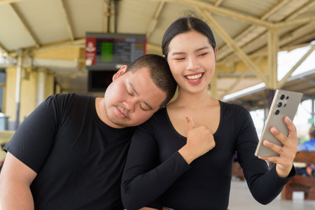 Young Asian couple in train station togetherの写真素材