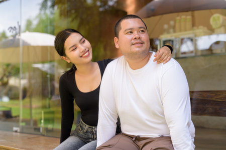 Happy Asian couple smiling in cafe restaurant togetherの写真素材