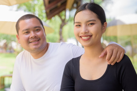 Happy Asian couple smiling together outdoorsの写真素材