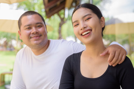 Happy Asian couple smiling in cafe restaurant togetherの写真素材