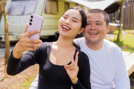 Asian couple camping in campground with their motorhome van car