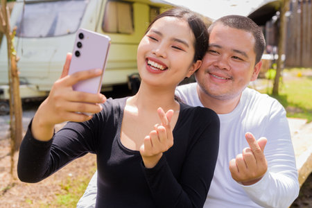 Asian couple camping in campground with their motorhome van carの写真素材