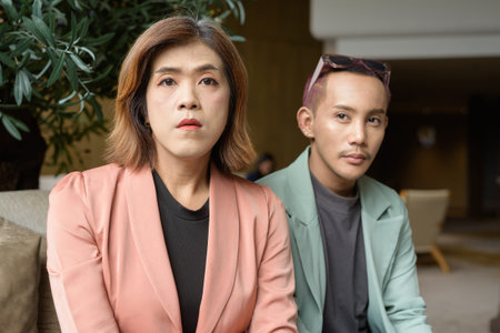 Asian transgender woman and non-binary coworkers working remotely in cafe