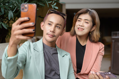 Asian transgender woman and non-binary coworkers working remotely in cafeの写真素材