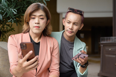 Asian transgender woman and non-binary coworkers working remotely in cafeの写真素材